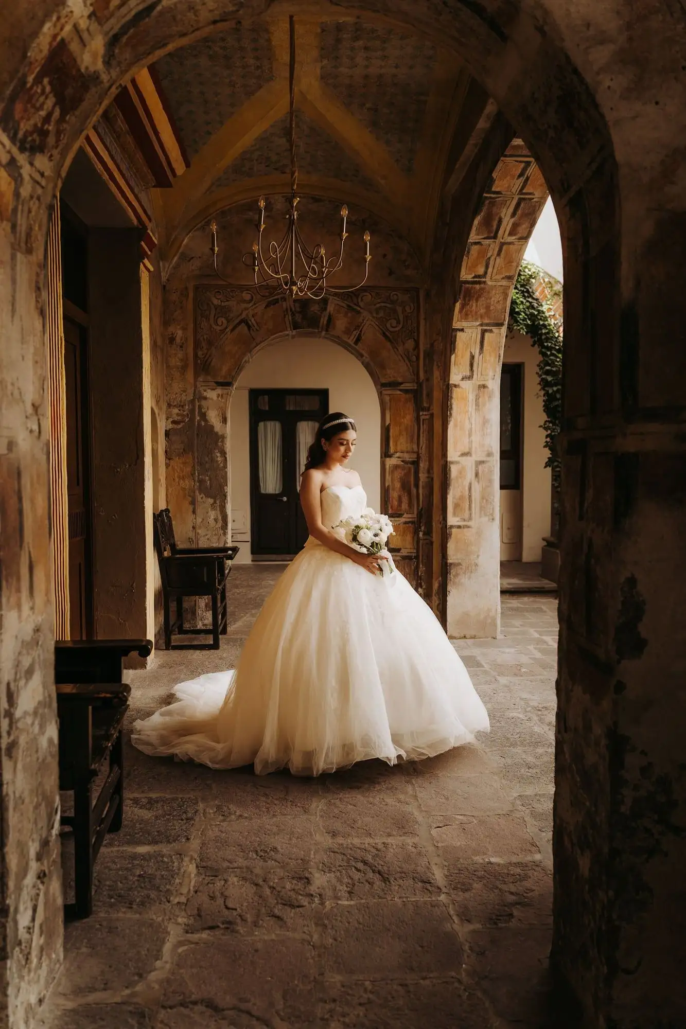 Vestido de novia strapless corte princesa con escote corazón en un patio de cantera iluminado por el sol