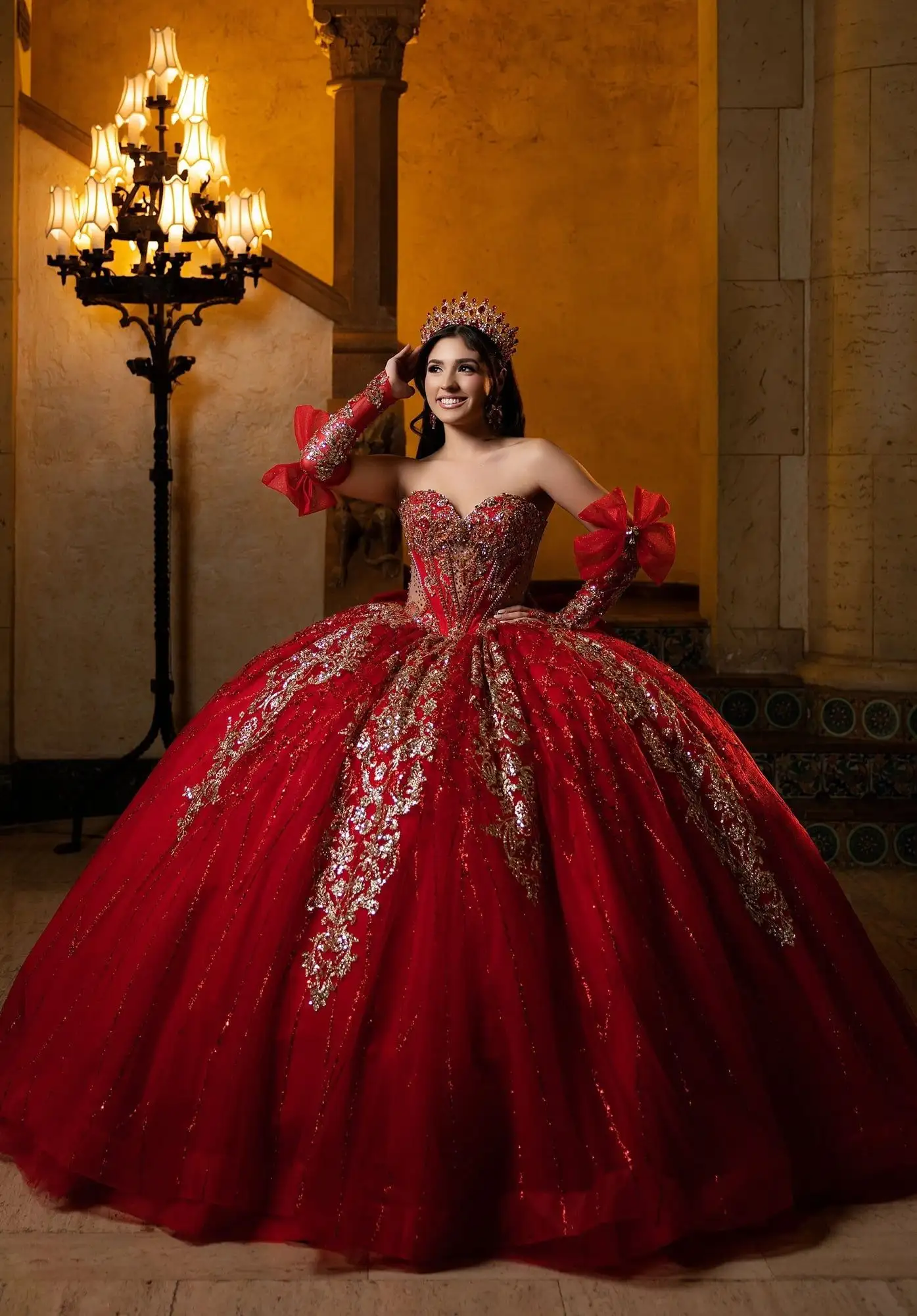 Vestido de quinceañera Morilee rojo con encaje dorado y guantes largos con moños